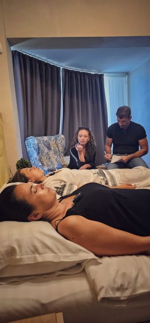 Calogero Grifasi pendant une session de formation Academy d'hypnose régressive ésotérique Méthode Grifasi, prenant des notes avec deux participantes en transe